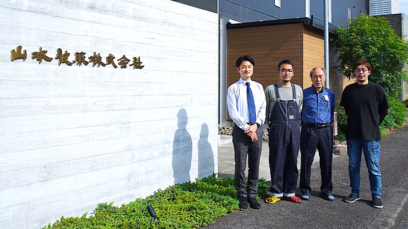 写真左から「STAR OVERALL」ディレクター 山本 陵氏（山本被服株式会社／取締役）、同開発マネージャー 富所 勢氏（山本被服株式会社／営業第一部 課長）、山口孝一氏（山本被服株式会社／工場長）、同プロジェクトリーダー 石井智洋氏（山本被服株式会社／刺繍室 デザイナー）